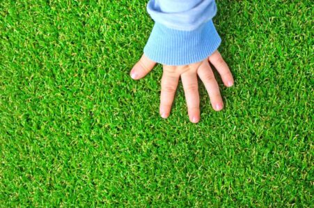 A kid touching artificial grass