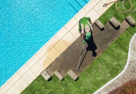 A guy installing artificial turf in pool